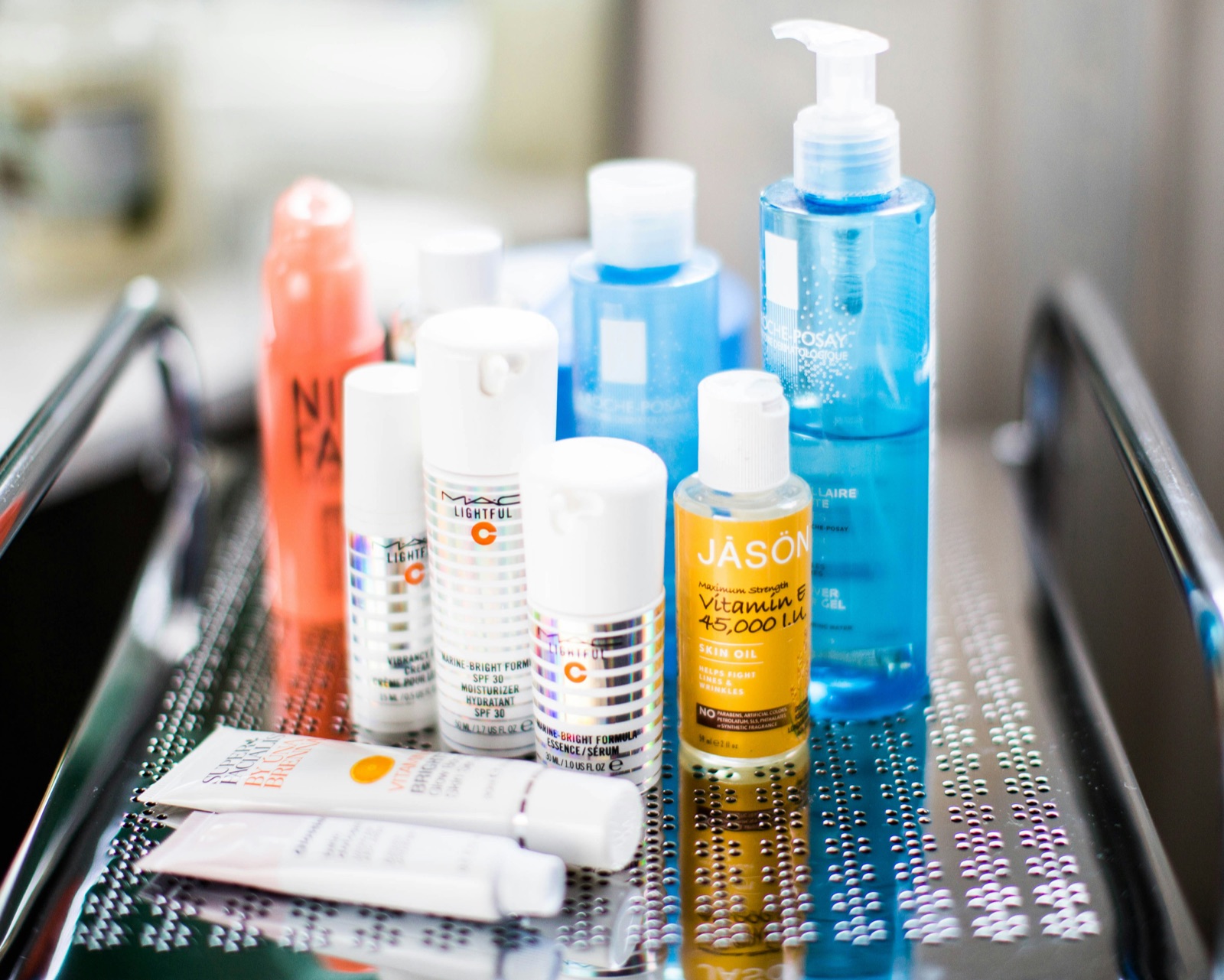 Assorted skincare serums and products being layered